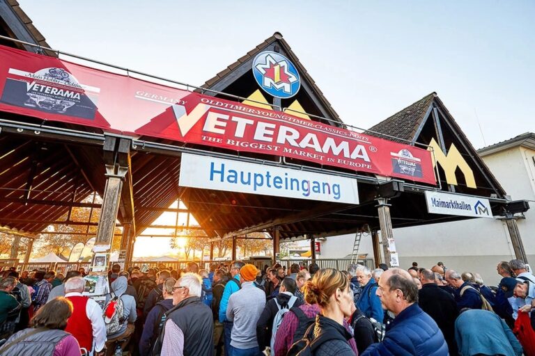 Haupteingang der Veteranenmesse ‚Veterama‘ mit Banner und einem dichten Besucherandrang, Sonnenlicht im Hintergrund.
