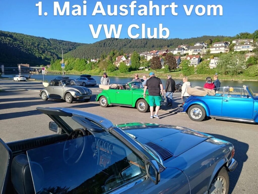 Mehrere klassische Volkswagen-Cabriolets mit Personen auf einem Parkplatz am Flussufer bei sonnigem Wetter, oben Text zur Ausfahrt des VW-Clubs.